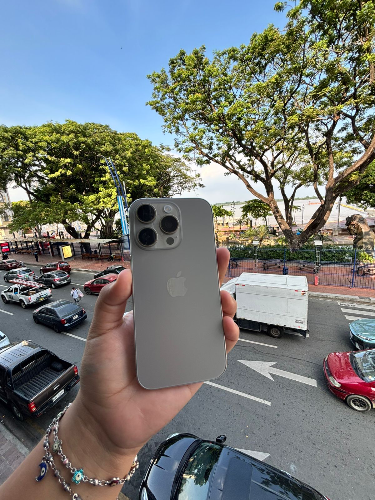 iPhone Pro en la mano con fondo urbano